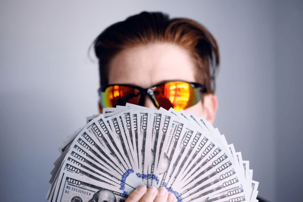 man with sunglasses holding money buying promotional gifts