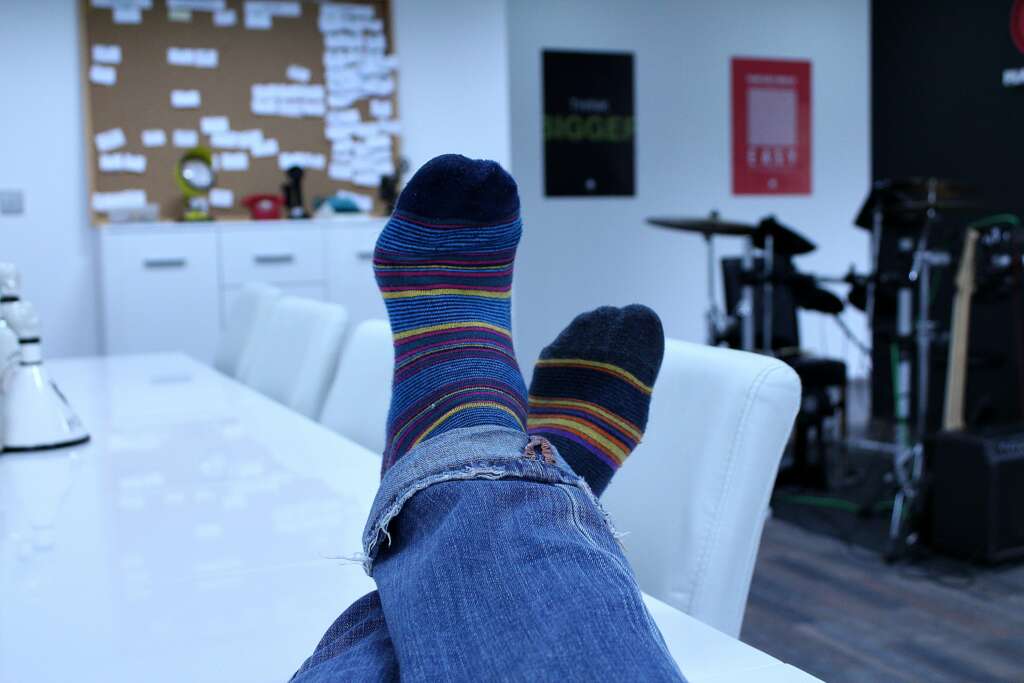 A person's legs crossed over on a table showing off their socks. 
