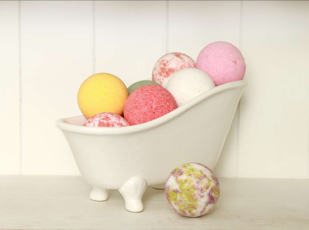 Bunch of colorful bath bombs in a small bathtub