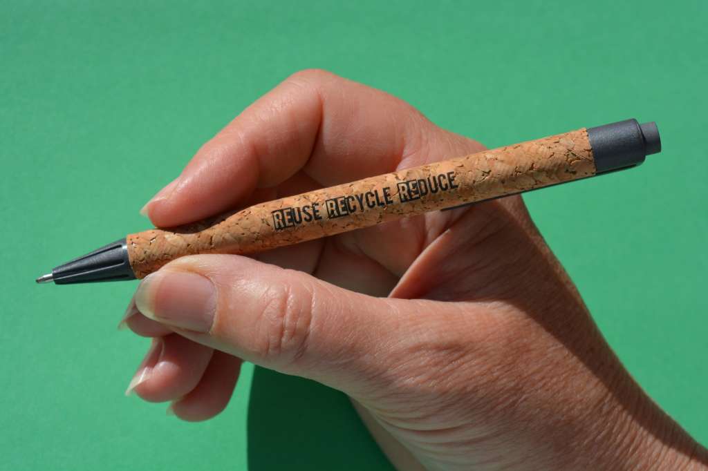 ReUse, Recycle, Reduce. Slogan in words on a pen made from recycled plastic and sustainable cork