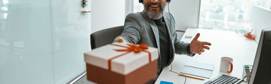 Smiling male operator holding a gift box