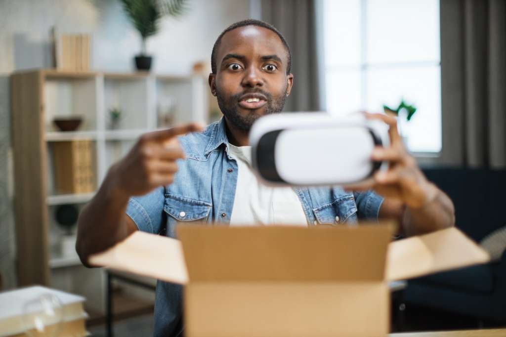 African man opening parcel box with new VR glasses