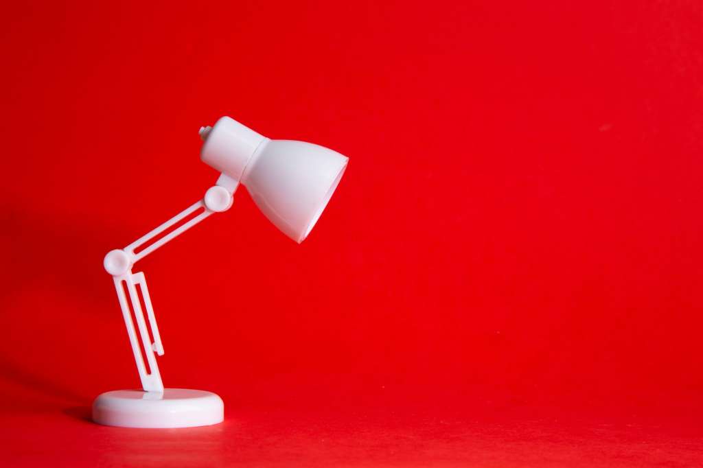 Desk lamp on red background with Idea Conceptual