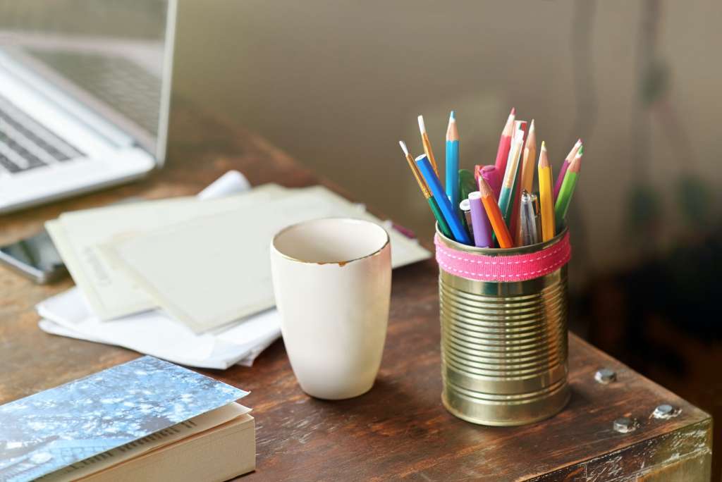 Make your creative space work for you. A desk with pencils, a cup and greeting cards.