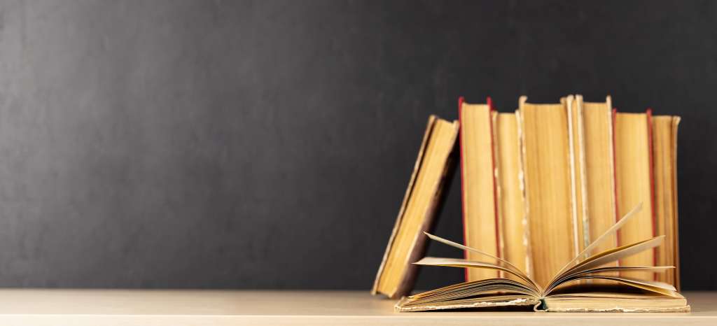 Old books on a table, with one book open