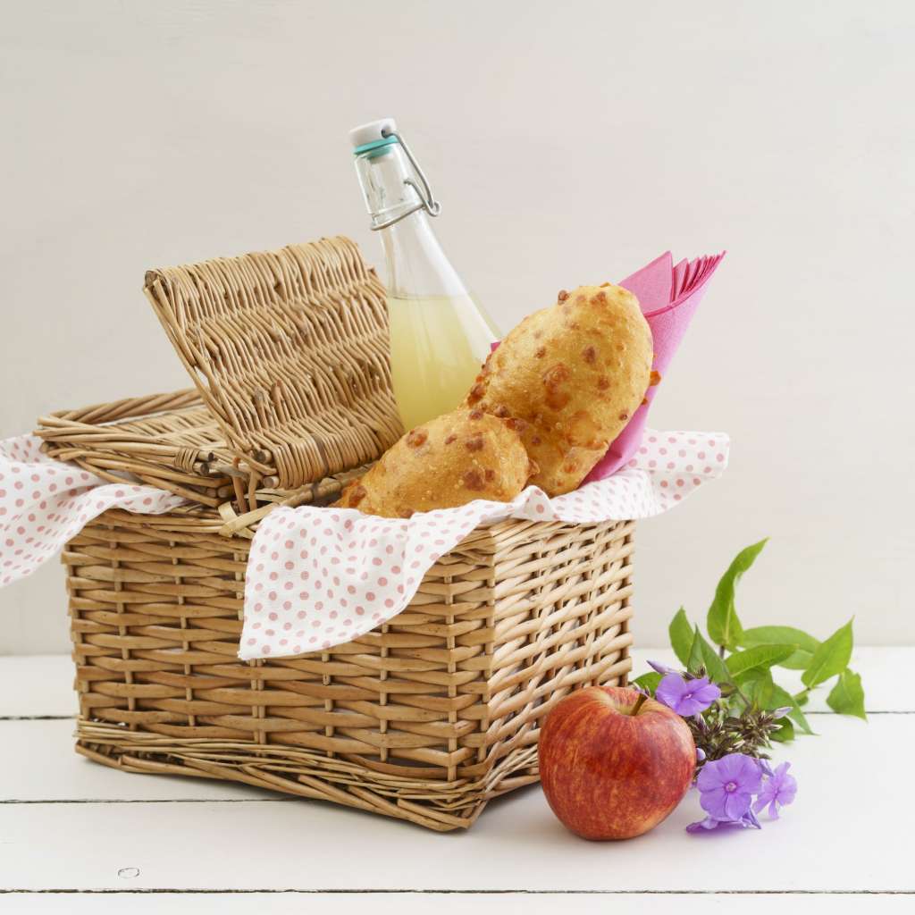 Picnic basket with cheese baguettes and fruit juice