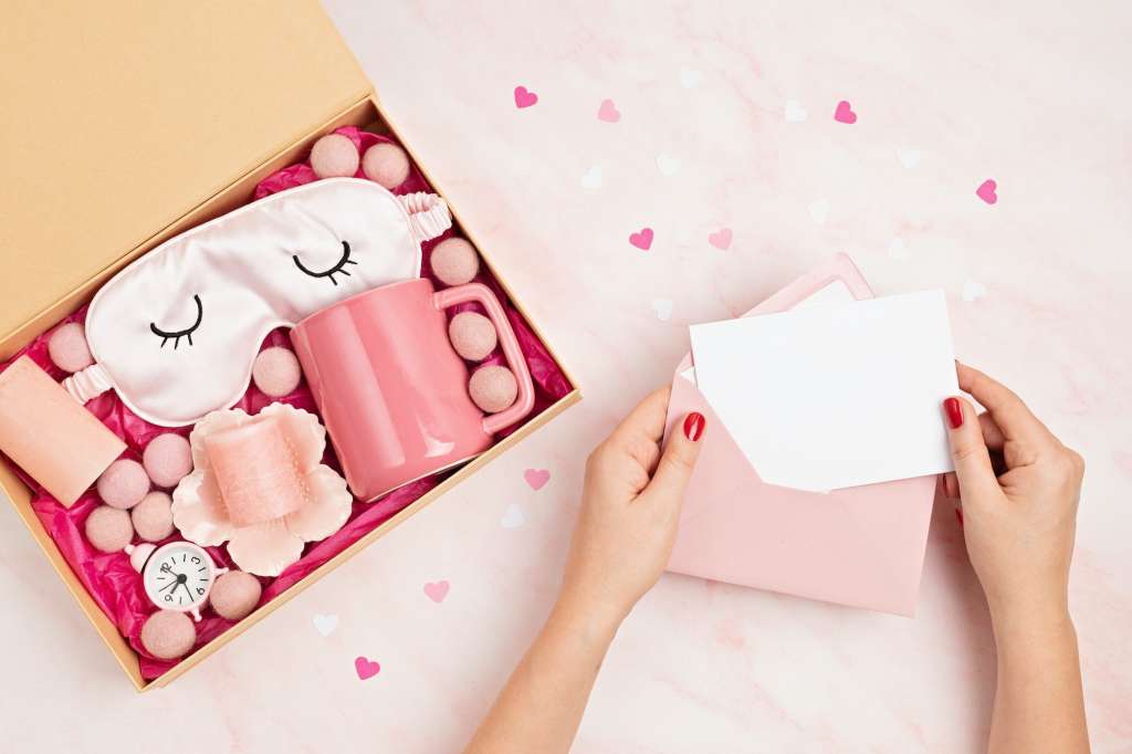 Preparing care package, seasonal gift box with tea cup, candles and sleeping mask