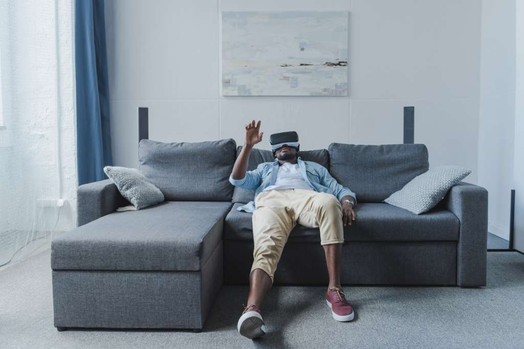 African american man using virtual reality headset at home