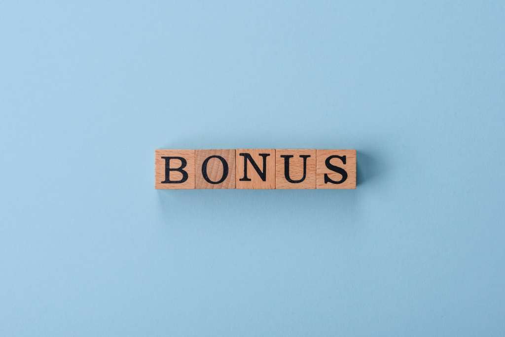 The inscription Bonus made of wooden cubes on a plain background